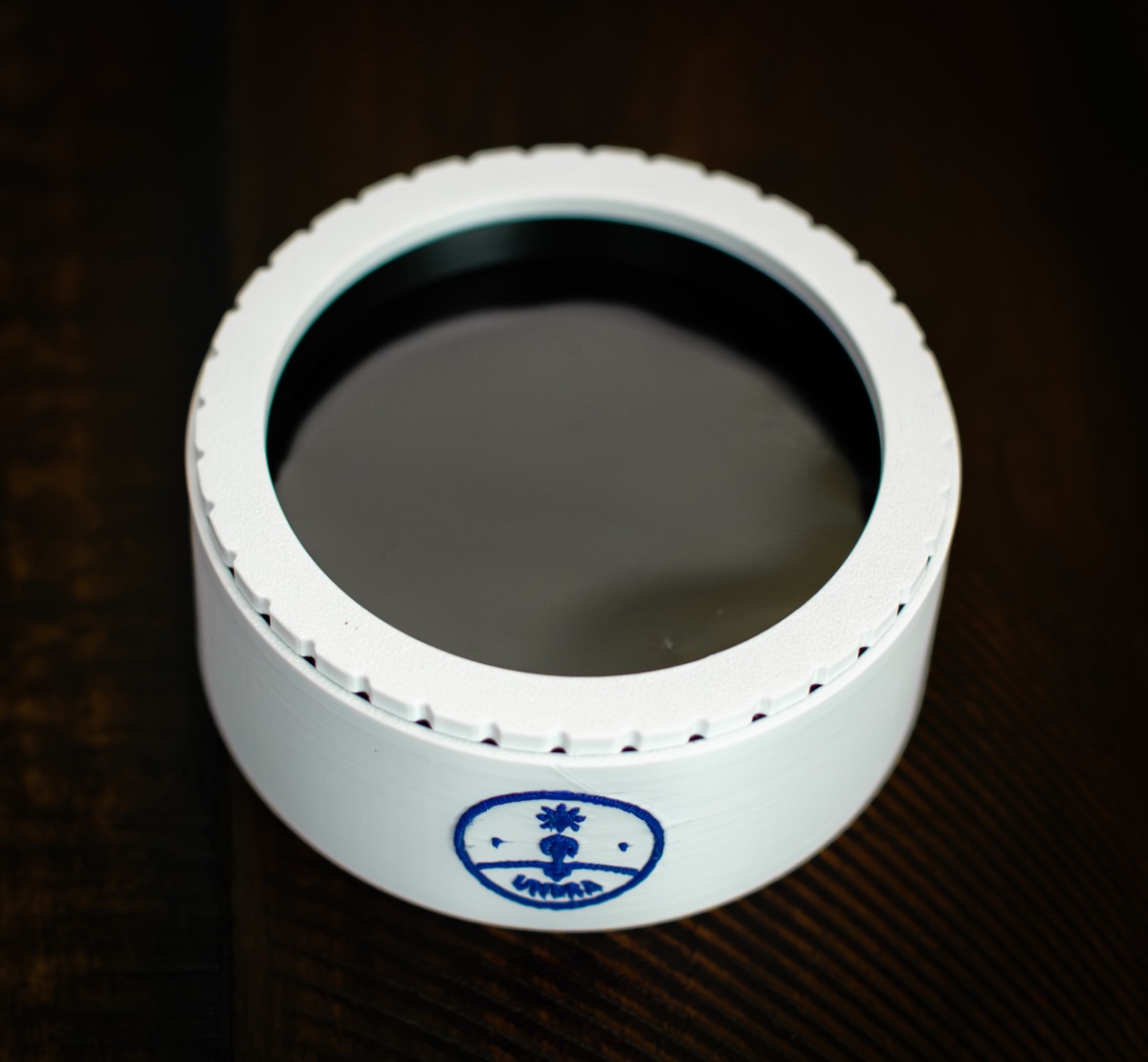 Top-down view of the assembled filter showing the solar film clamped flat by the knurled printed ring.